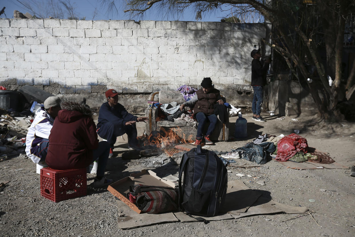Migrants sit around a fire at a shelter on the U.S.-Mexico border in Ciudad Juarez, Mexico, Monday, Dec. 19, 2022. Pandemic-era immigration restrictions in the U.S. known as Title 42 are set to expire on Dec. 21. (AP Photo/Christian Chavez)
