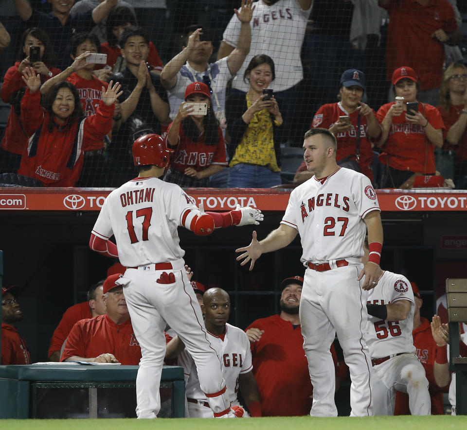 Los Angeles Angels designated hitter Shohei Ohtani, left, gets congratulations from Mike Trout (27) after Ohtani hit a solo home run against the Texas Rangers during the eighth inning of a baseball game in Anaheim, Calif., Wednesday, Sept. 26, 2018. The Angels won 3-2. (AP Photo/Alex Gallardo)