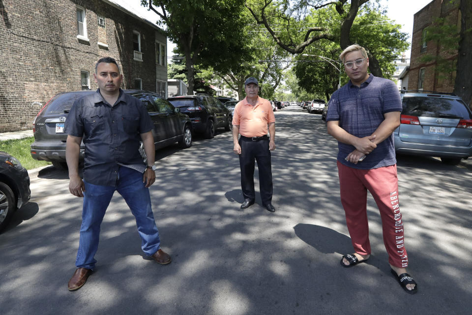 Raul Montes Jr., left, Juan Rodriguez, center, and Radames Pina pose for a photo Tuesday, June 2, 2020, in Chicago. Activists and residents are angry that Little Village businesses and homes are being vandalized amid protests sparked by the death of George Floyd in police custody in Minneapolis, on May 25. (AP Photo/Nam Y. Huh)