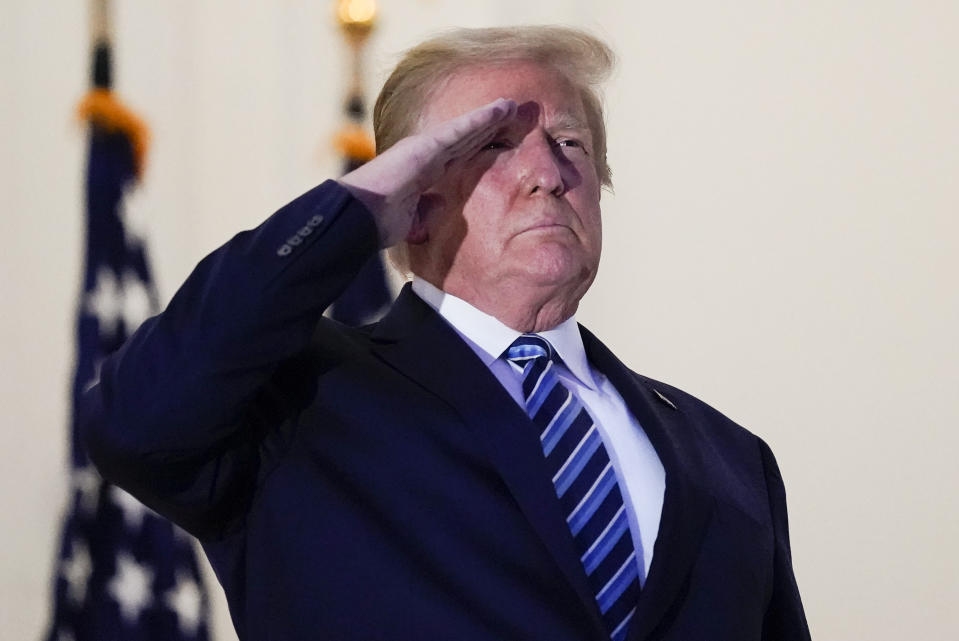 President Donald Trump salutes to Marine One as he stands on the balcony outside of the Blue Room as returns to the White House Monday, Oct. 5, 2020, in Washington, after leaving Walter Reed National Military Medical Center, in Bethesda, Md. Trump announced he tested positive for COVID-19 on Oct. 2. (AP Photo/Alex Brandon)