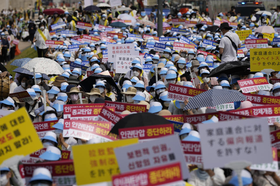 Unification Church followers hold signs during a rally in downtown Seoul, South Korea, Thursday, Aug. 18, 2022, protesting negative Japanese media coverage of their religion after the suspect in the assassination of former Japanese Prime Minster Shinzo Abe blamed the church for his family’s troubles.(AP Photo/Lee Jin-man)