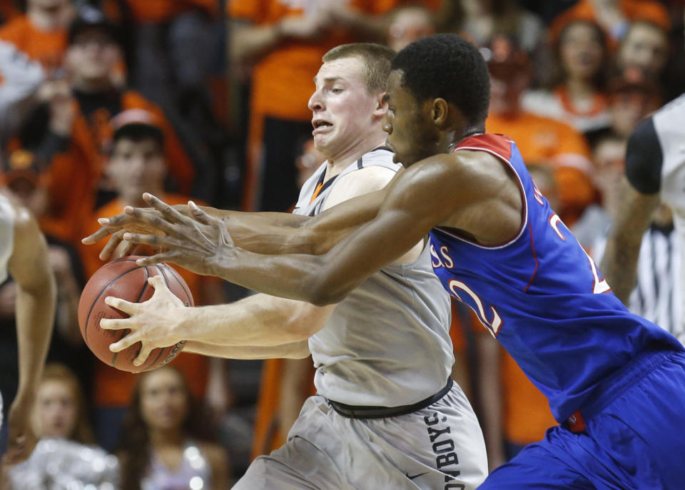 Oklahoma State guard Phil Forte (13) steals a pass intended for Kansas guard Andrew Wiggins (22) in the second half of an NCAA college basketball game in Stillwater, Okla., Saturday, March 1, 2014. Oklahoma State won 72-65. (AP Photo/Sue Ogrocki)