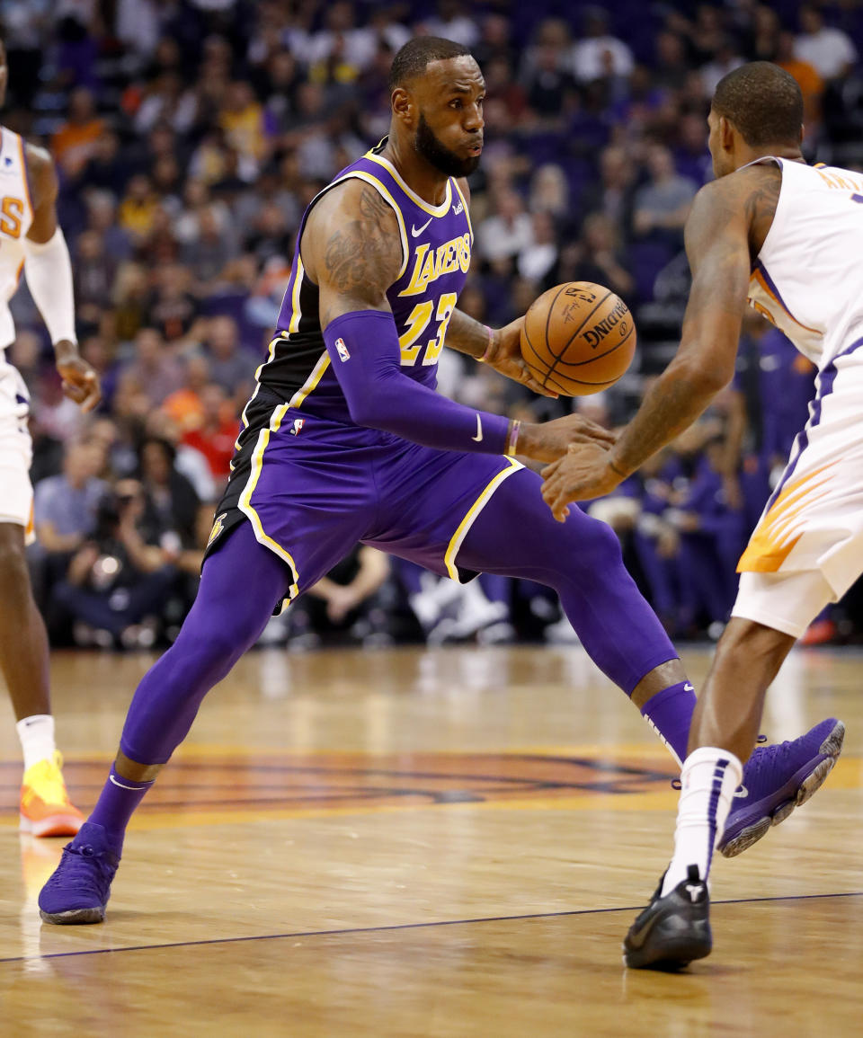 Los Angeles Lakers forward LeBron James (23) drives past Phoenix Suns forward Trevor Ariza during the first half of an NBA basketball game, Wednesday, Oct. 24, 2018, in Phoenix. (AP Photo/Matt York)