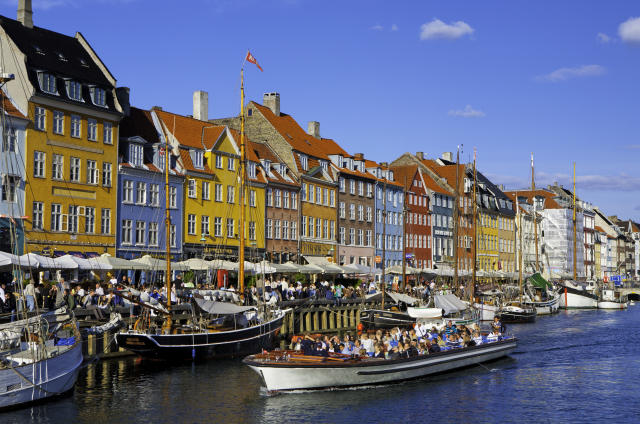 Denmark, Copenhagen, Nyhavn. Boats and people on harbour. Outdoor cafes