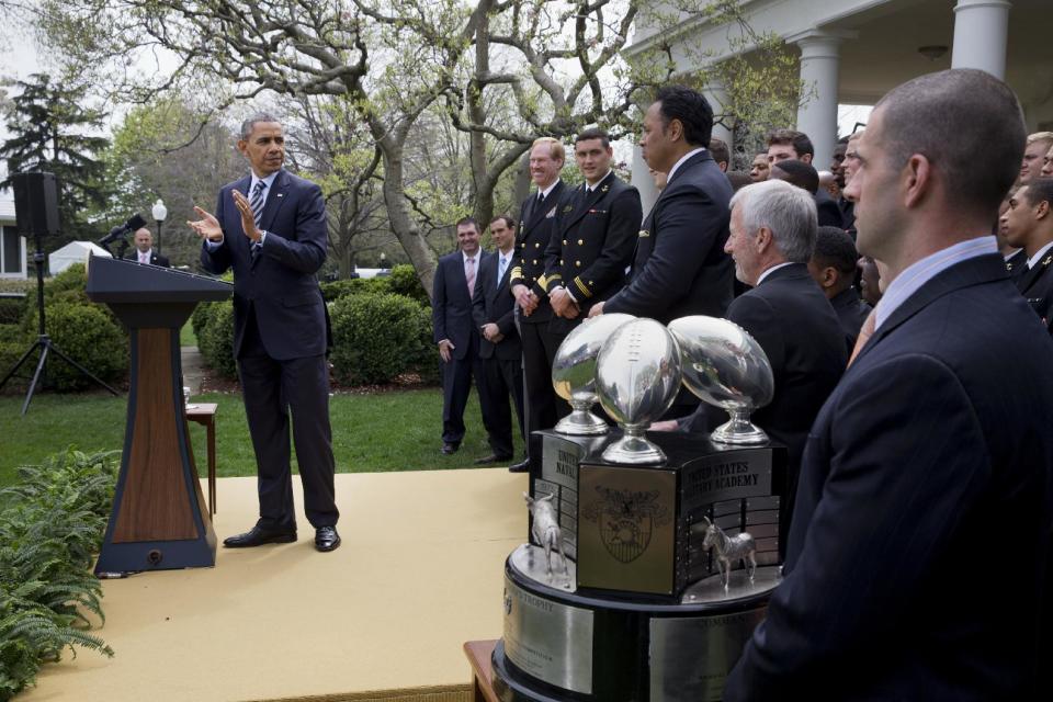 President Barack Obama applauds as he presents the Commander-in-Chief's Trophy to the United States Naval Academy football team, Friday, April 18, 2014, during a ceremony in the Rose Garden of the White House in Washington. Navy finished the 2013 season with a 9-4 record, winning the Commander-in-Chief's Trophy for the ninth time in the last 11 years. (AP Photo/Jacquelyn Martin)