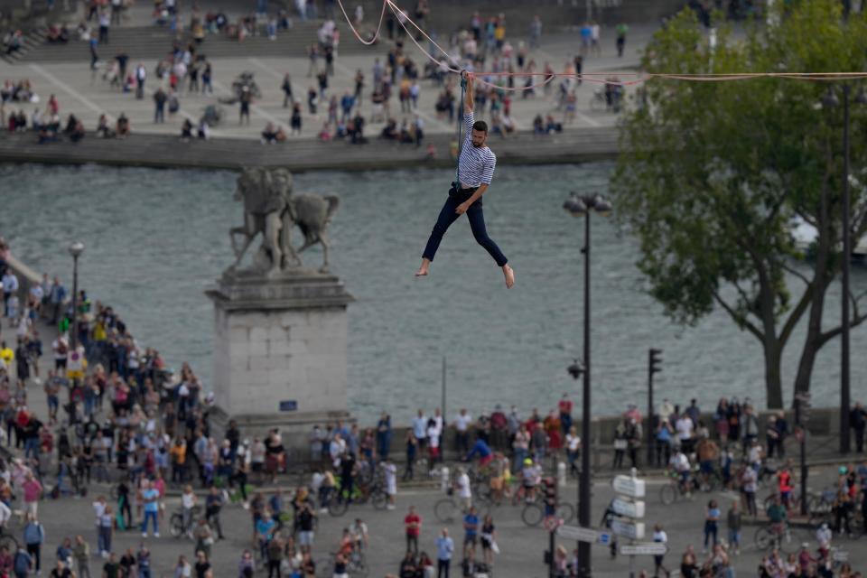 French slackliner Nathan Paulin performs on the second time on a 70-meter-high slackline between the Eiffel Tower and the Chaillot Theater and faces a crowd of thousands.