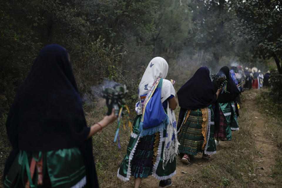 Purepechas Indigenous women carry burning copal incense as they escort a flame from Erongaricuaro, where residents kept the fire alive for one year, to Ocumicho in Michoacan state, Mexico, Wednesday, Jan. 31, 2024. A new flame will be lit in Ocumicho at the “New Fire” ceremony on Feb. 2 to mark the new year, after extinguishing the old fire on Feb. 1 which is considered an orphan day that belongs to no month and is used for mourning and renewal. (AP Photo/Eduardo Verdugo)