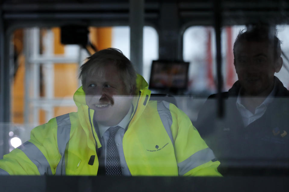 Britain's Prime Minister Boris Johnson steers a tug boat during a General Election campaign trail stop in the port of Bristol, England, Thursday, Nov. 14, 2019. Britain goes to the polls on Dec. 12. (AP Photo/Frank Augstein, Pool)