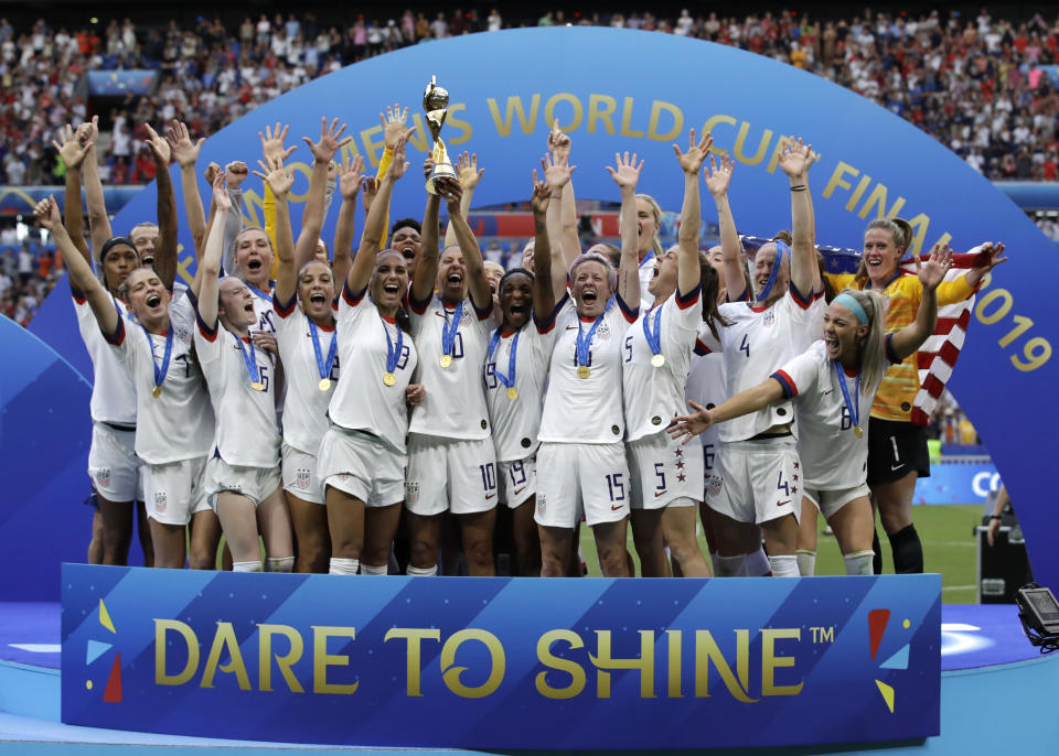 FILE - The United States' team celebrate with the trophy after winning the Women's World Cup final soccer match between against Netherlands at the Stade de Lyon in Decines, outside Lyon, France. As the nation celebrates the 50th anniversary of Title IX, a new poll finds Americans are split on how much progress has come from the landmark women's rights law. (AP Photo/Alessandra Tarantino, File)