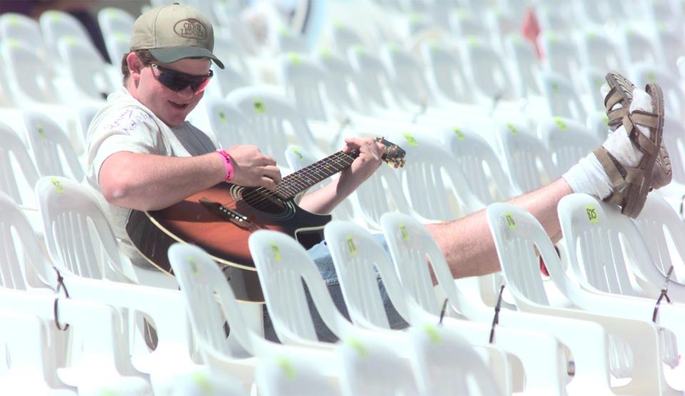 James Lann strums a few tunes in between acts on April 24, 1998, at Country Thunder USA from his seats.