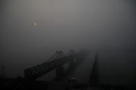 The sun rises through fog over the Friendship and the Broken bridges over the Yalu River connecting the North Korean town of Sinuiju and Dandong in China's Liaoning province, March 30, 2017. REUTERS/Damir Sagolj