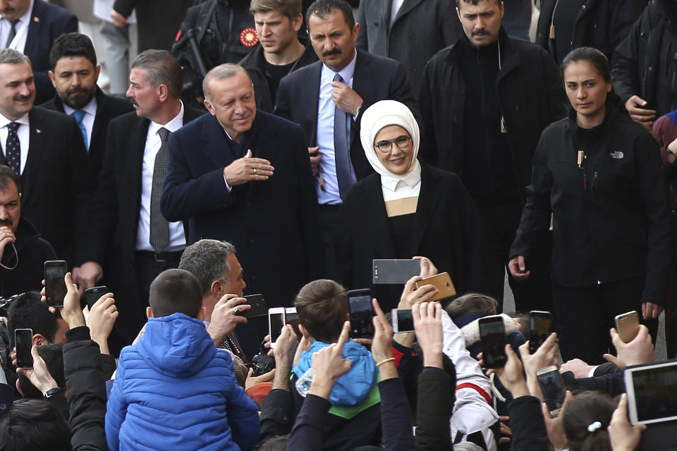 Turkey's President Recep Tayyip Erdogan and his wife Emine Erdogan wave to the people they arrive at a polling station in Istanbul, Sunday, March 31, 2019. Turkish citizens have begun casting votes in municipal elections for mayors, local assembly representatives and neighborhood or village administrators that are seen as a barometer of Erdogan's popularity amid a sharp economic downturn. (AP Photo/Emrah Gurel)