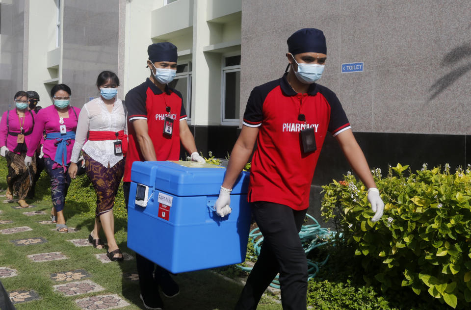 FILE - In this Jan. 14, 2021, health workers carry COVID-19 vaccine during vaccination at a hospital in Bali, Indonesia. The global death toll from COVID-19 has topped 2 million.(AP Photo/Firdia Lisnawati, File)