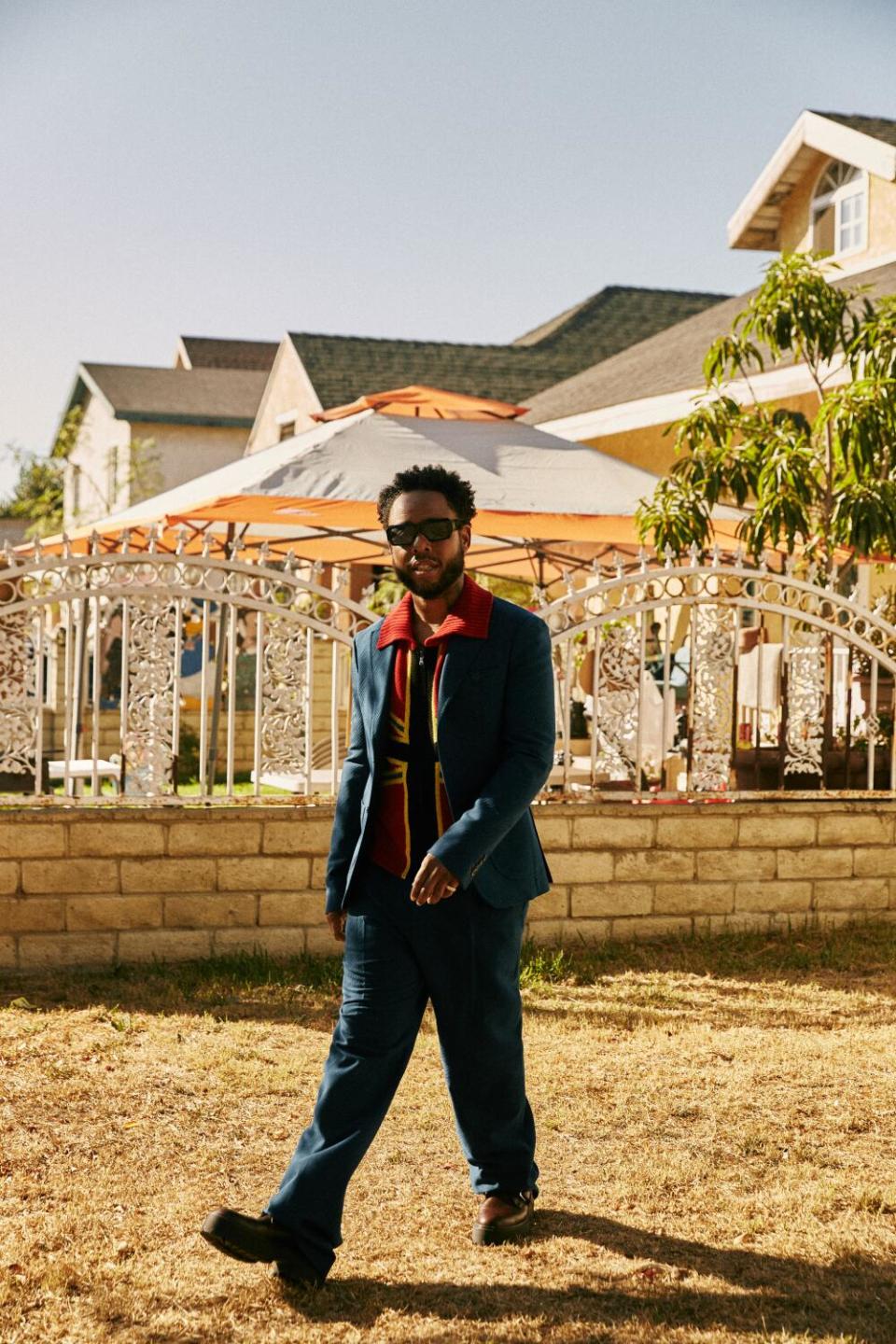 Terrace Martin walks through a yard.