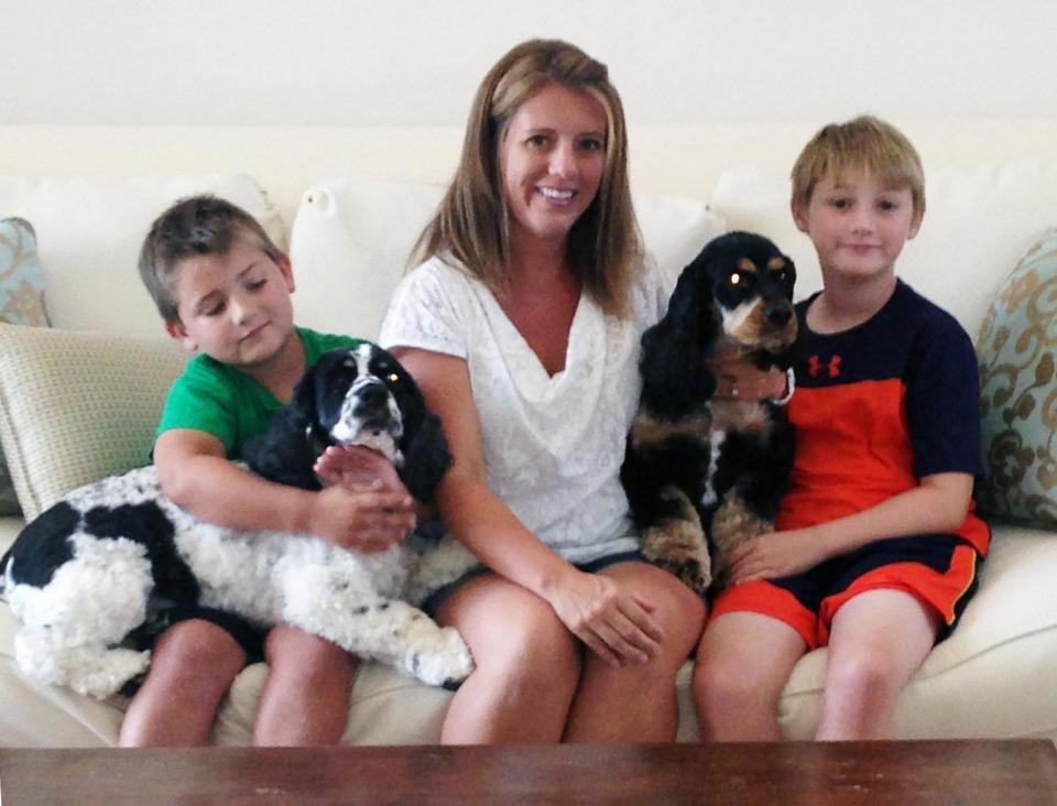 In this Friday, Aug. 2, 2013 photo provided by Laura Morse, middle, Morse poses with her sons Justin, left, and Logan, along with their two adopted dogs, Zeus, left, and Thor at their home in Naples, Fla. Animal shelters across the country try to place two or more pets in the same home. (AP Photo/Bella Morse)