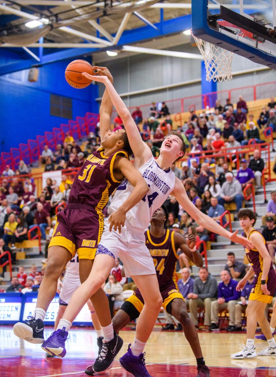 South's Gavin Wisley (14) and North's Bril Kante (31) battle for a rebound during the Bloomington North versus Bloomington South boys basketball sectional final at Martinsville High School on Saturday, March 5, 2022.