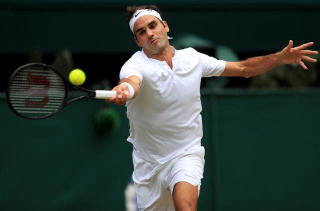 Roger Federer hits a tennis ball with his racket at Wimbledon