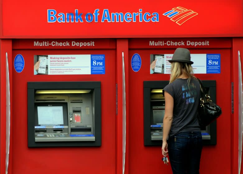 A Bank of America customer uses an ATM at a branch in Hollywood on October 19, 2010. Two top US banks are moving on the offensive as they struggle to put the foreclosures quagmire behind them, but the scandal continues to menace the financial sector. Bank of America, the country's largest bank by assets, said it was lifting freezes on more than 100,000 foreclosure cases in 23 states, insisting it had not found any flaws in their processing. Bank of America, which had announced a nationwide moratorium on foreclosures to review its paperwork on October 8, nevertheless said the freeze will stay in place for now in the remaining 27 states. AFP PHOTO/Mark RALSTON (Photo credit should read MARK RALSTON/AFP/Getty Images) ** TCN OUT **