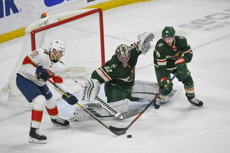 Florida Panthers center Dominic Toninato, left, and Minnesota Wild defenseman Jared Spurgeon, right, battle for control of the puck in front of Wild goalie Alex Stalock during the first period of an NHL hockey game Monday, Jan. 20, 2020, in St. Paul, Minn. (AP Photo/Craig Lassig)