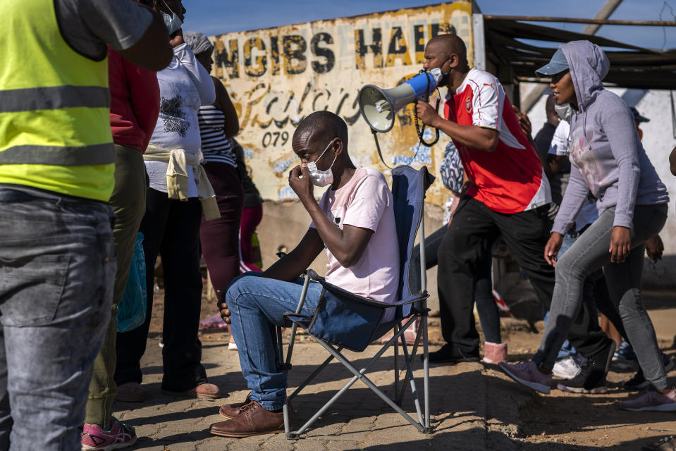 People line up to receive food handouts in the Olievenhoutbos township of Midrand, South Africa, Saturday May 2, 2020. though South Africa begun a phased easing of its strict lockdown measures on May 1, its confirmed cases of coronavirus continue to increase. (AP Photo/Jerome Delay)