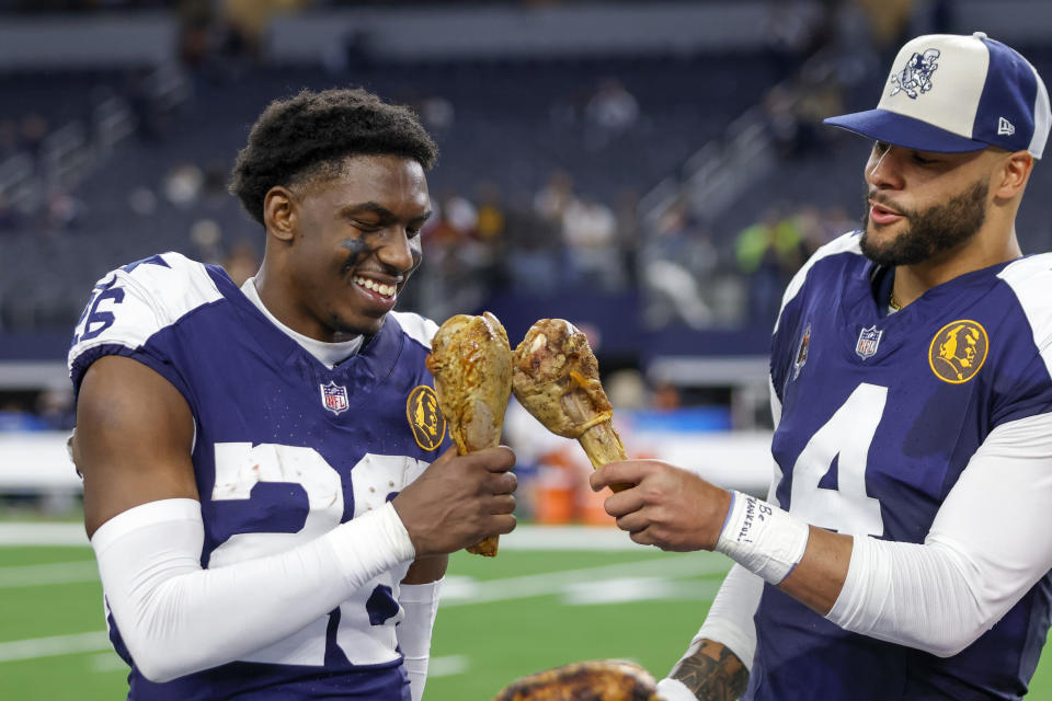 ARLINGTON, TX - NOVEMBER 23: Dallas Cowboys quarterback Dak Prescott (4) and cornerback DaRon Bland (26) celebrate eating a turkey leg after the game between the Dallas Cowboys and the Washington Commanders on November 23, 2023 at AT&T Stadium in Arlington, Texas. (Photo by Matthew Pearce/Icon Sportswire via Getty Images)