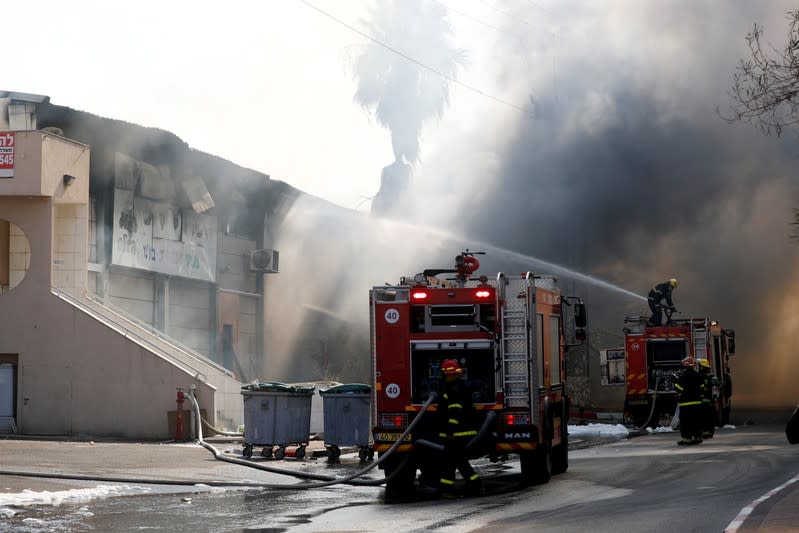 Israeli firefighters work to extinguish a fire in a factory in Sderot, southern Israel