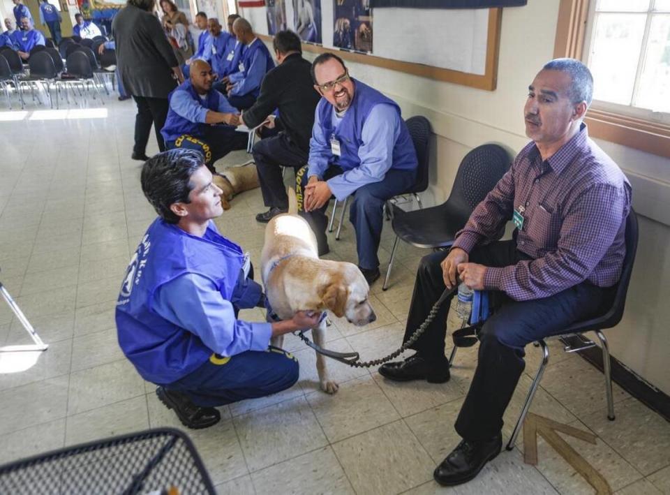 Christopher Bain, left, and Wesley Bird were inmate trainers for Rusty, a service dog presented to Henry Garcia. A program at California Men’s Colony teaches inmates to train dogs for service to veterans and first responders. David Middlecamp/dmiddlecamp@thetribunenews.com