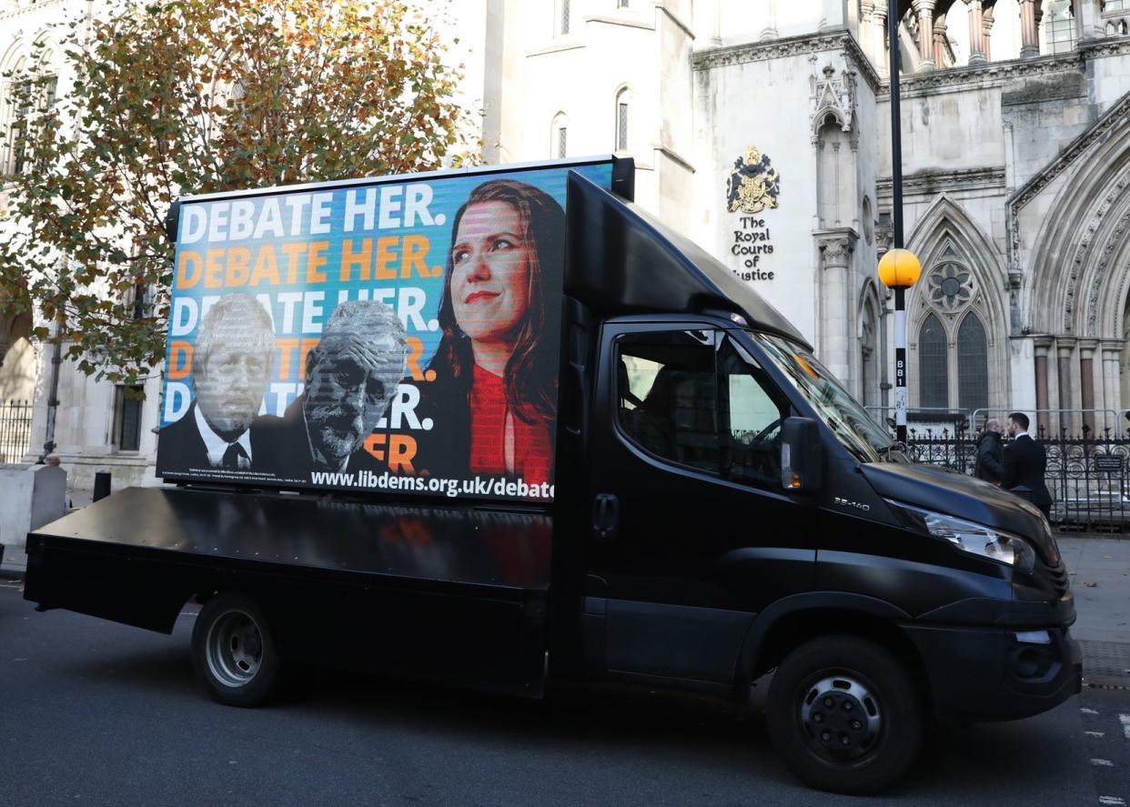 An advertising van showing Boris Johnson, Jeremy Corbyn and Jo Swinson outside the Royal Courts of Justice: PA