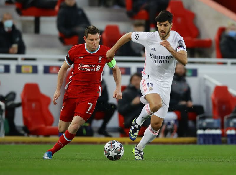 Foto del miércoles del futbolista del Real Madrid Marco Asensio peleando el balón con el jugador del Liverpool James Milner.