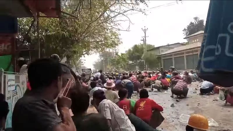 Demonstrators stay low on the ground during an anti-coup protest in Myaing