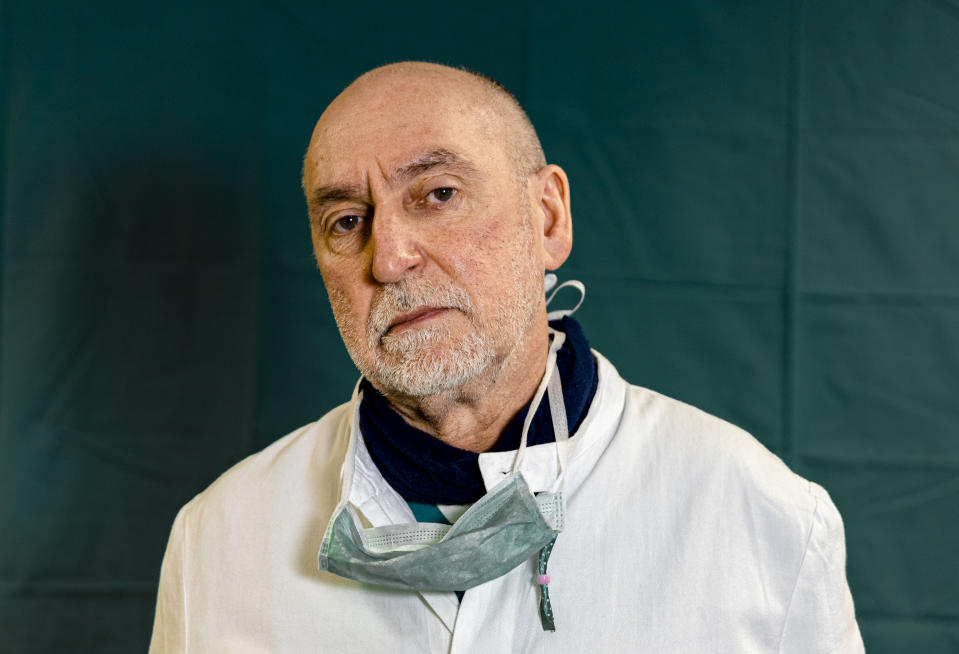 Director of the Intensive Care unit Gabriele Tomasoni, 65, poses for a portrait at the Brescia Spedali Civic Hospital, in Brescia, Italy Friday, March 27, 2020. The intensive care doctors and nurses on the front lines of the coronavirus pandemic in Italy are almost unrecognizable behind their masks, scrubs, gloves and hairnets. "These are patients who are starving for air," said Tomasoni. "We know these are elderly patients," Tomasoni said at the end of his shift on Friday evening. "They need closeness. Tenderness." (AP Photo/Luca Bruno)