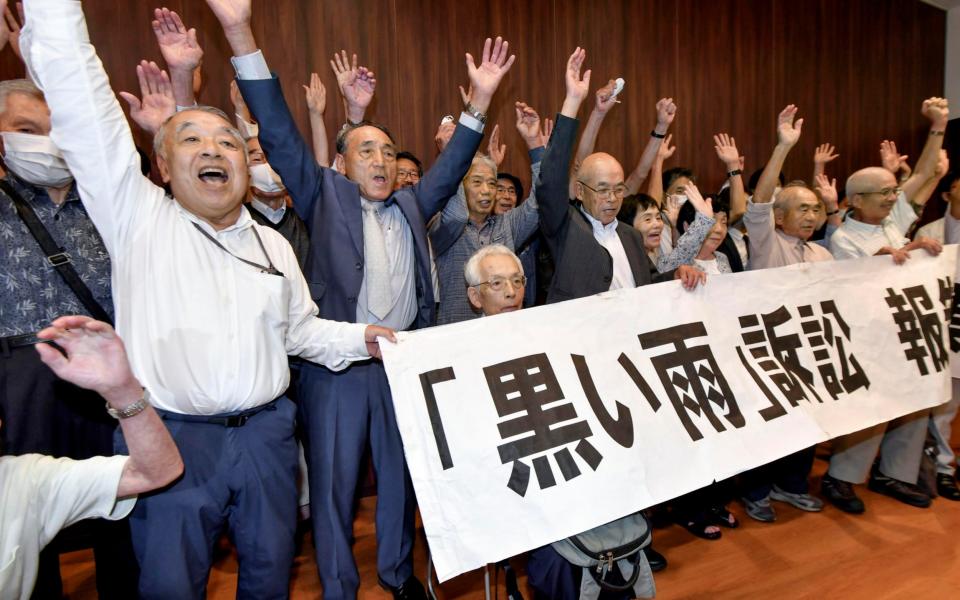 The plaintiffs celebrate following the historic ruling at a court in Hiroshima -  115323+0900/ Kyodo News