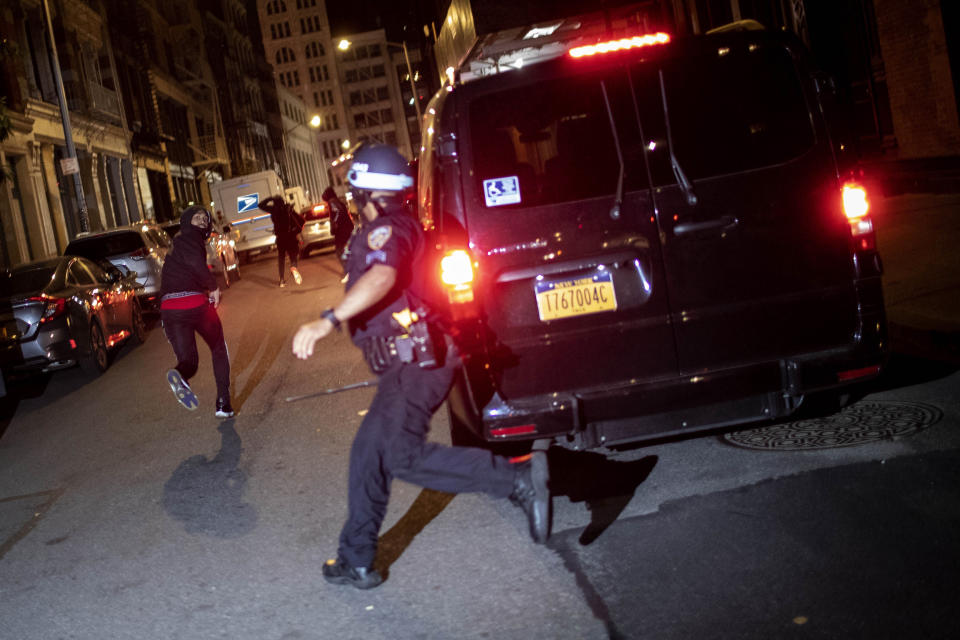 FILE - In this June 1, 2020, file photo, a protester runs as he is chased by police in New York. A grim video of a Chicago police officer fatally shooting a 13-year-old boy is once again shining a light on the policies that govern foot chases. (AP Photo/Wong Maye-E, File)