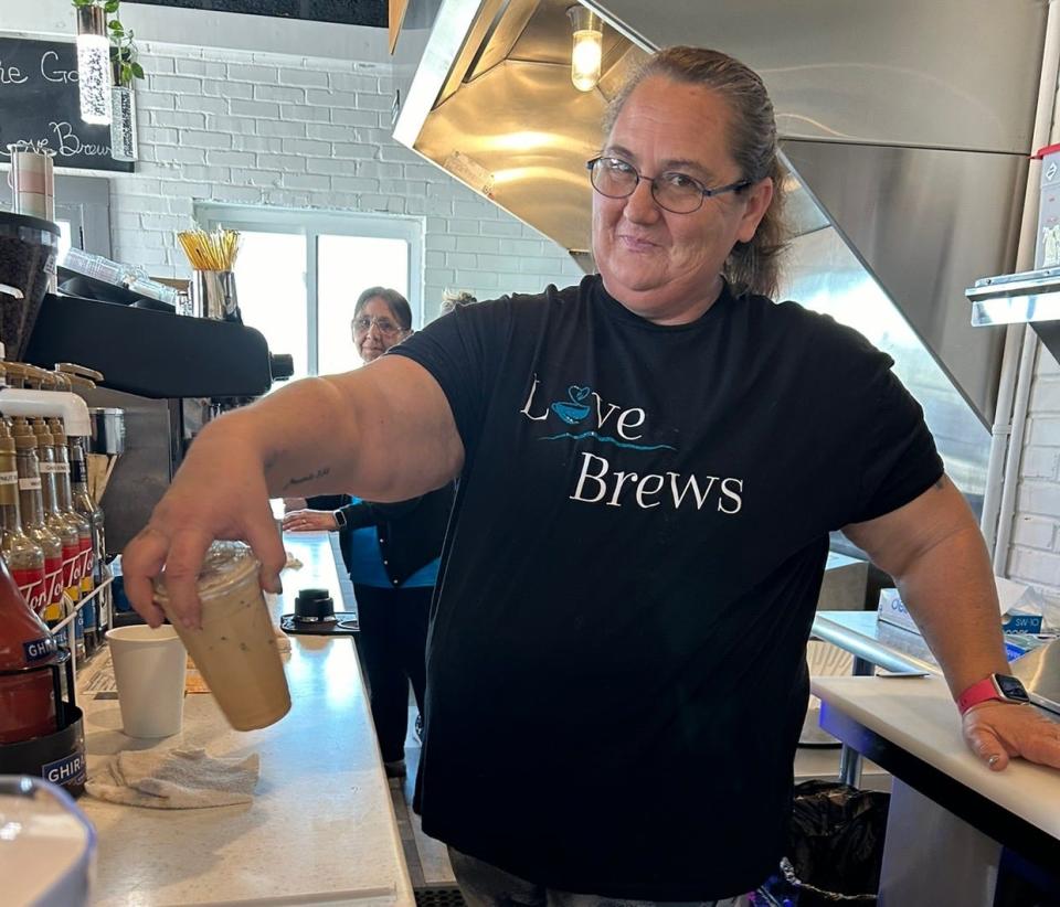 Brandy Sutton swirls a specialty coffee, mixing it behind the counter.