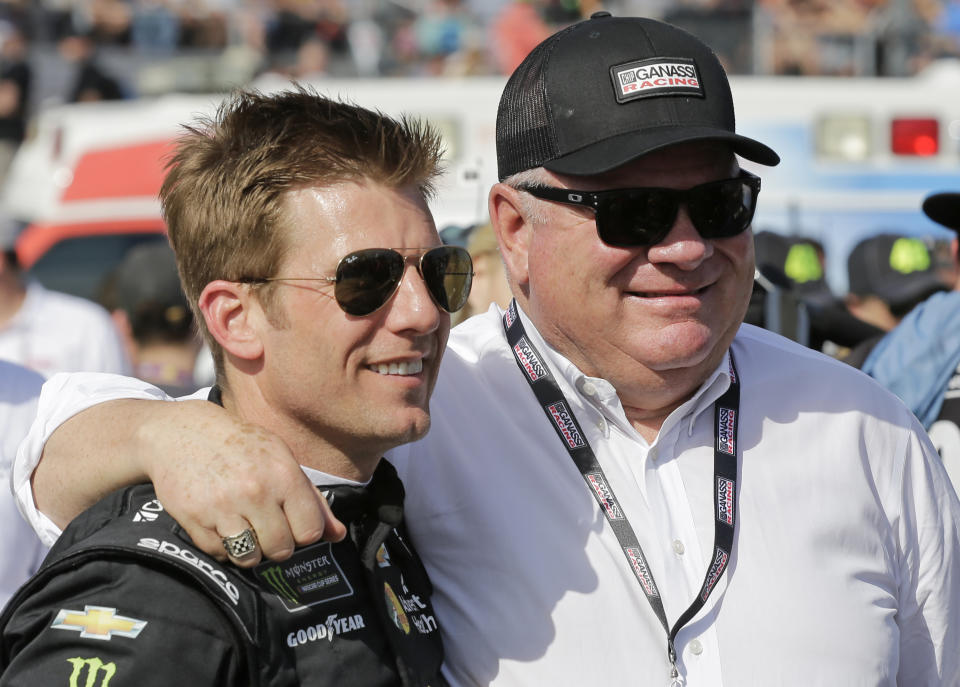 FILE - Jamie McMurray, left, and car owner Chip Ganassi greet each other on pit road before a NASCAR Daytona 500 auto race at Daytona International Speedway, in Daytona Beach, Fla., in this Sunday, Feb. 17, 2019, file photo. Ganassi won the Daytona 500 and the Brickyard 400, two of the biggest races in NASCAR, with McMurray in 2010. Chip Ganassi has sold his NASCAR team to Justin Marks, owner of Trackhouse Racing, and will pull out of the nation's top stock car series at the end of this season. Ganassi fields two cars in the Cup Series but will transfer his North Carolina race shop and all its assets to Marks for 2022. “He made me a great offer that required my attention,” Ganassi told The Associated Press on Wednesday, June 30, 3031, as the sale was announced. (AP Photo/Terry Renna, File)