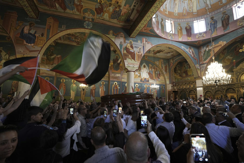 Mourners gather for the funeral of slain Al Jazeera veteran journalist Shireen Abu Akleh at a church lin the Old City of Jerusalem, Friday, May 13, 2022. Abu Akleh, a Palestinian-American reporter who covered the Mideast conflict for more than 25 years, was shot dead Wednesday during an Israeli military raid in the West Bank town of Jenin.(AP Photo/Ariel Schalit)