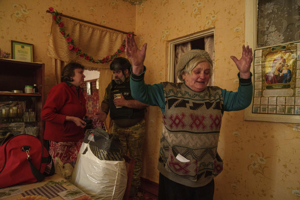 Valentyna reacts before leaving her home during evacuation to Kharkiv, in Vovchansk, Ukraine, on Saturday, May 11, 2024. (AP Photo/Evgeniy Maloletka)