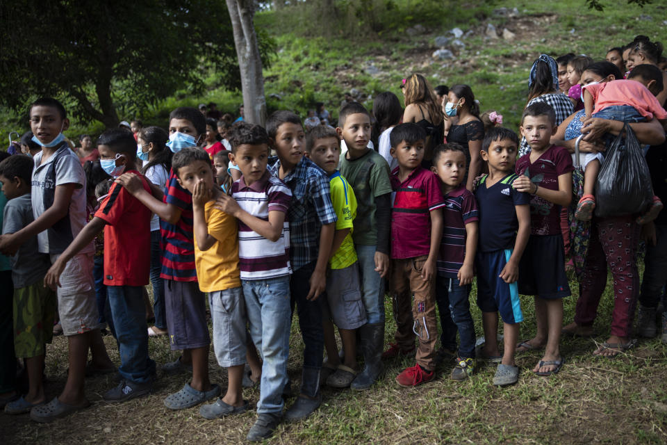 Children wait in line to receive donated used toys at a ceremony with government officials who arrived to open envelopes containing the bids from companies seeking to build homes for the victims of Hurricane Eta and Iota, in Mission San Francisco de Asis, Honduras, Monday, June 28, 2021. Friar Leopoldo Serrano, who runs the mission, warned the community to be wary: “In Honduras we live a daily storm more damaging than hurricanes, the storm of corruption. The authorities deceive us with false promises. That is why I tell you that I still have doubts about the construction of these houses.” (AP Photo/Rodrigo Abd)