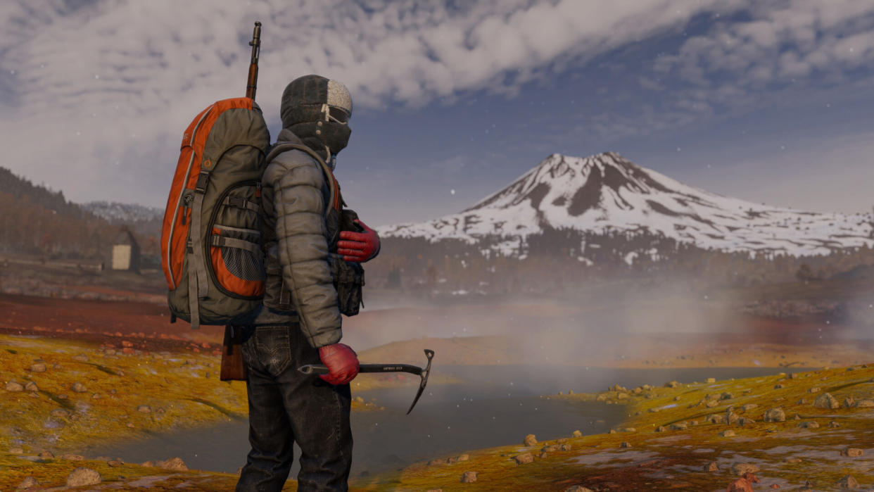  Screenshot from DayZ Frostline: A Man in arctic survival gear stands in front of a steaming sulfur pot with a snowy volcano cone in the background. 