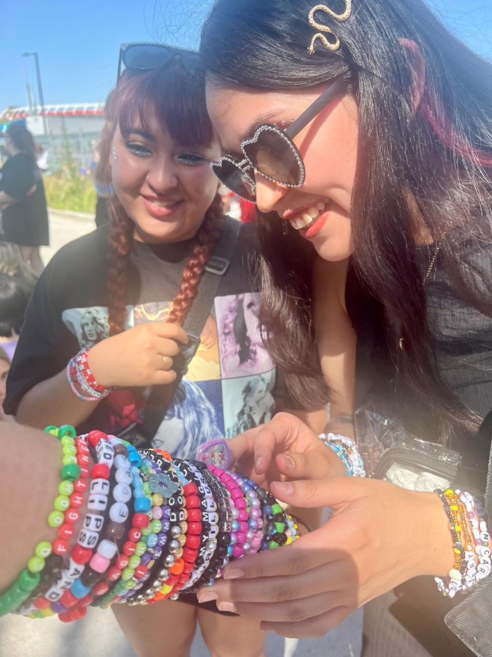 Swifties trading friendship bracelets on Sunday night before her rescheduled concert (Andrea Cavallier / The Independent)