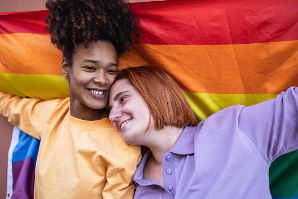 two people holding a pride flag