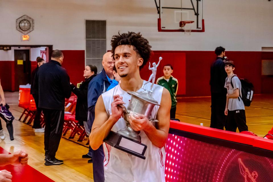 New Bedford's Carter Barbosa grabs the trophy after the Whalers' 3-0 victory over GNB Voc-Tech.