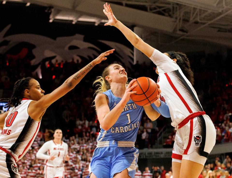 North Carolina’s Alyssa Ustby drives to the basket between N.C. State’s Aziaha James and Mimi Collins during the first half of the Wolfpack’s game on Thursday, Feb. 1, 2024, at Reynolds Coliseum in Raleigh, N.C. Kaitlin McKeown/kmckeown@newsobserver.com