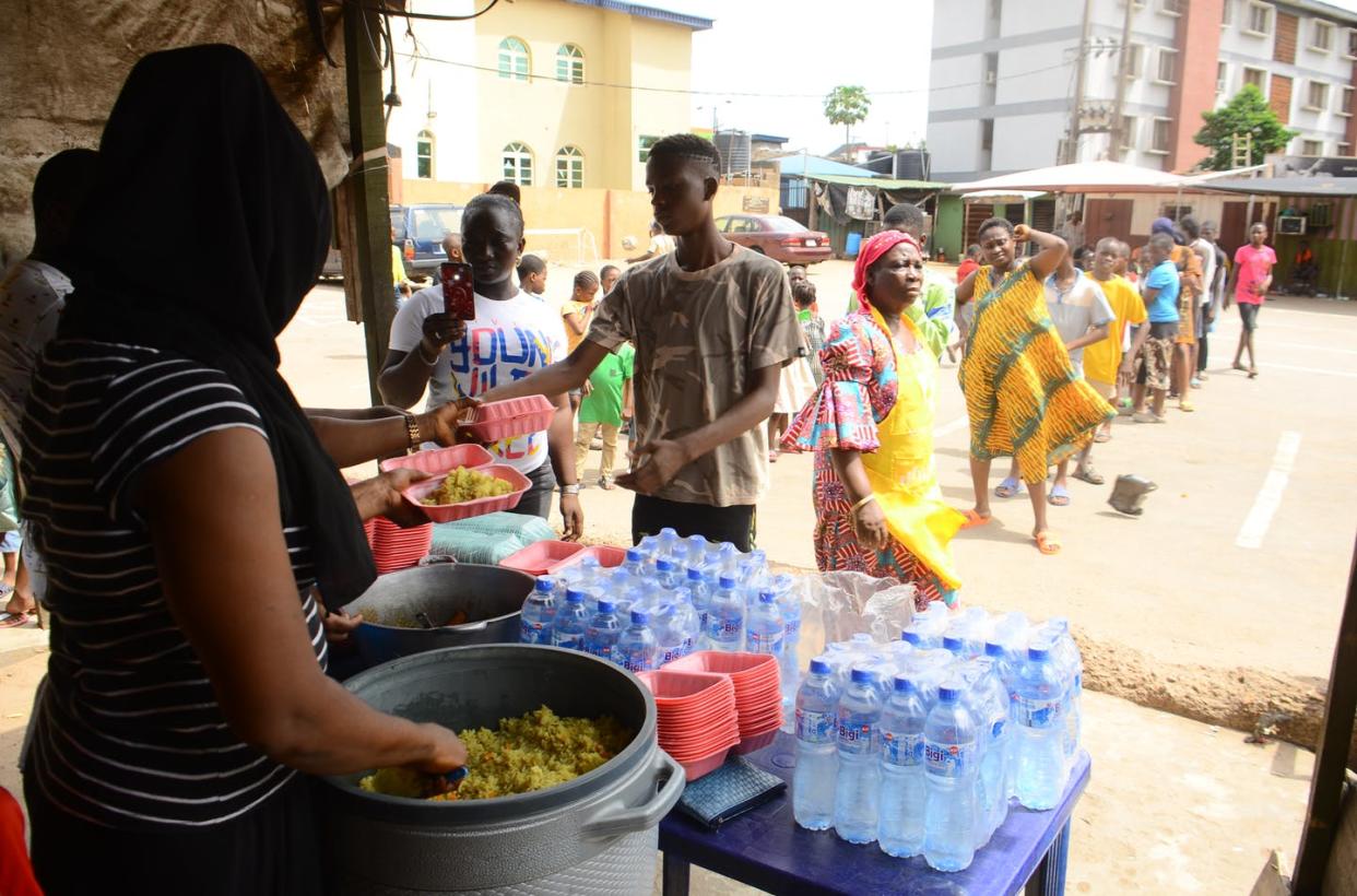 <span class="caption">When people need food aid, like these Nigerians, research finds they are more susceptible to extremist recruitment efforts.</span> <span class="attribution"><a class="link " href="https://www.gettyimages.com/detail/news-photo/food-vendor-serving-food-as-people-queue-in-line-to-collect-news-photo/1210357836" rel="nofollow noopener" target="_blank" data-ylk="slk:Olukayode Jaiyeola/NurPhoto via Getty Images;elm:context_link;itc:0;sec:content-canvas">Olukayode Jaiyeola/NurPhoto via Getty Images</a></span>