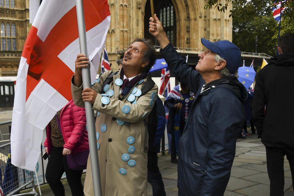 A pro-Brexit demonstrator holds an English flag outside the houses of Parliament, in London, Monday, Oct. 14, 2019.(AP Photo/Alberto Pezzali)