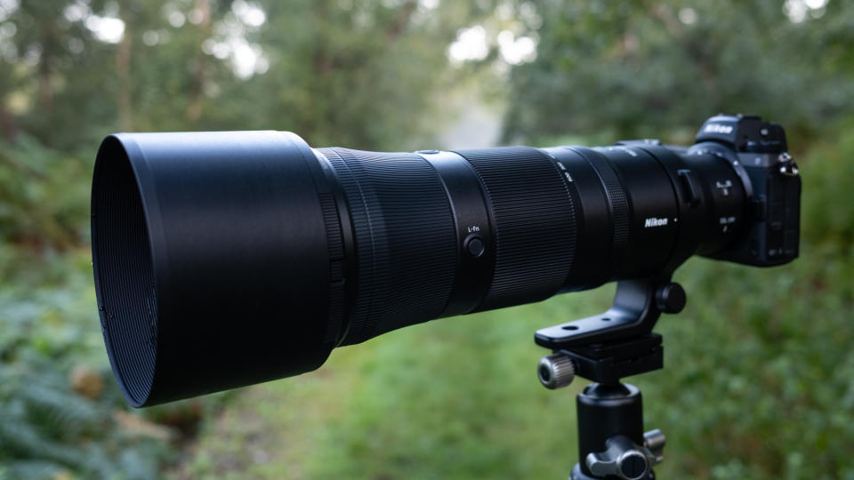 Close up photos of the Nikkor Z 180-600mm f/5.6-6.3 VR mounted on a tripod with foliage in the background