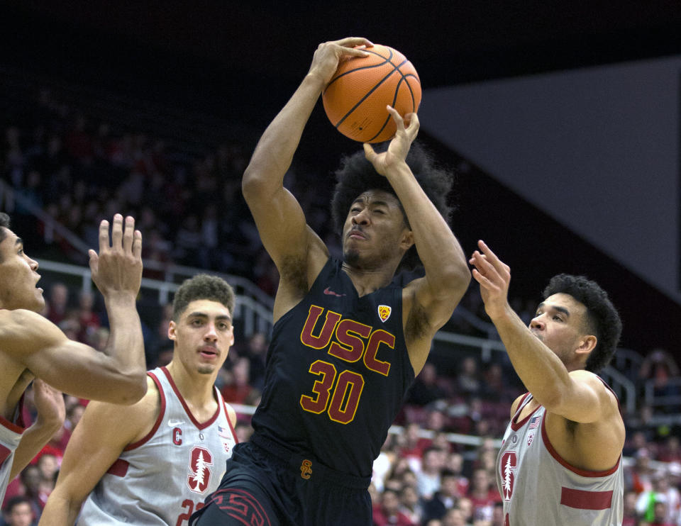 Southern California’s Elijah Stewart drives to the basket amid Stanford defenders. (AP Photo)