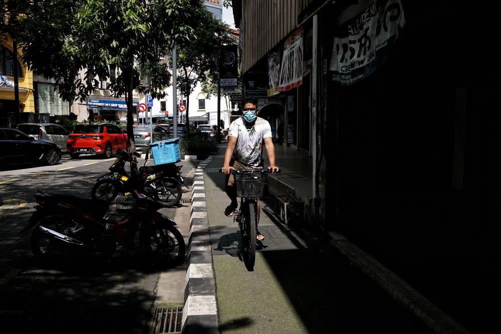 A man riding a bicycle is pictured wearing a protective mask in Kuala Lumpur November 28, 2021. — Picture by Ahmad Zamzahuri