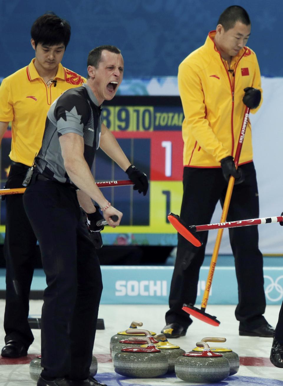 Canada's second E. J. Harnden shouts as China's third Xu Xiaoming (L) and China's skip Liu Rui (R) look on during their men's curling semifinal game at the 2014 Sochi Olympics in the Ice Cube Curling Center in Sochi February 19, 2014. REUTERS/Phil Noble (RUSSIA - Tags: OLYMPICS SPORT CURLING)