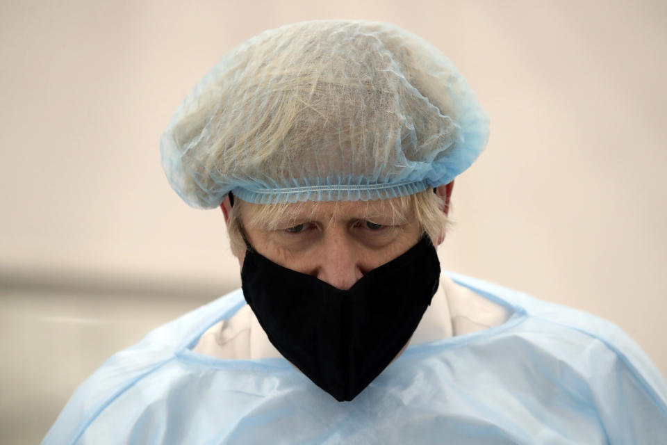 Britain's Prime Minister Boris Johnson, wearing a face mask to prevent the spread of the coronavirus, visits a PPE manufacturing facility during a visit to the north east of England, in Seaton Delaval, England, Saturday, Feb. 13, 2021. (AP Photo/Scott Heppell, Pool)